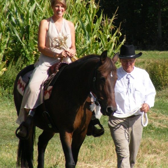 A bride on a horse rides into the wedding ceremony 