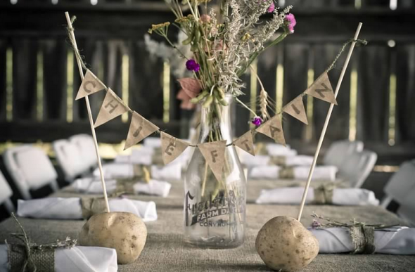 A barn wedding centerpiece with milk jar, flowers and burlap