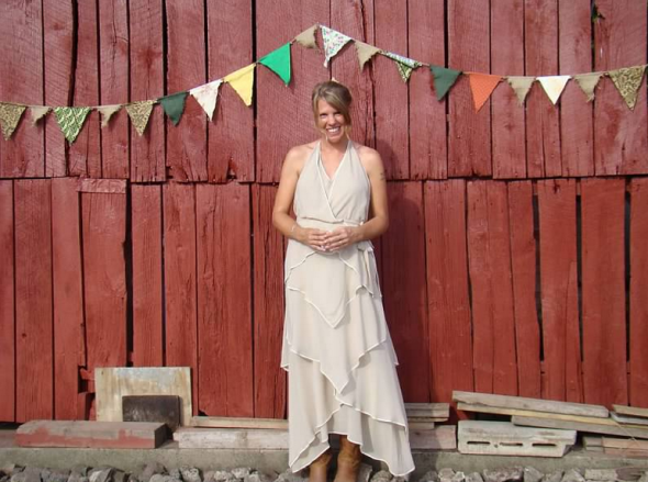 Rustic bride in front of barn at farm wedding