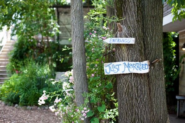 a just married wood sign hanging on a tree