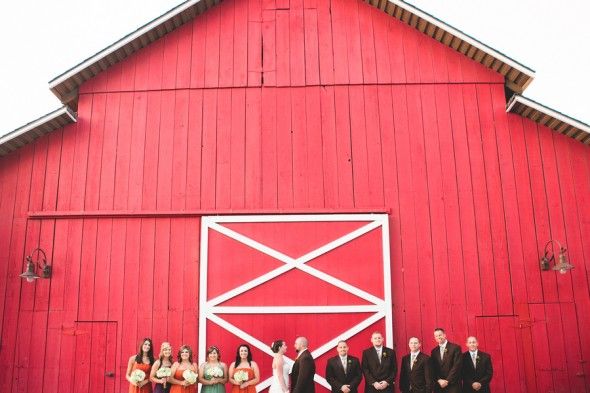 A wedding party in front of a red barn in California 