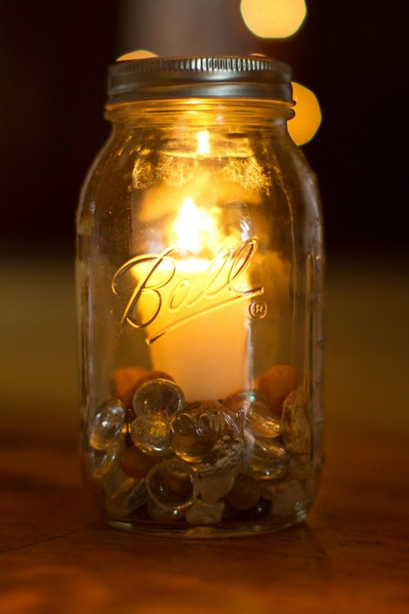 A mason jar used as a candle holder with rocks