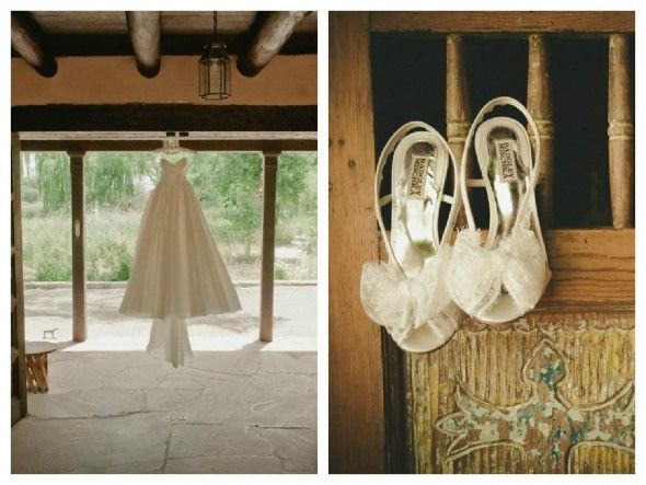 A rustic wedding gown hangs in a barn