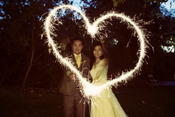 Bride and groom Use Sparklers to Draw a Heart