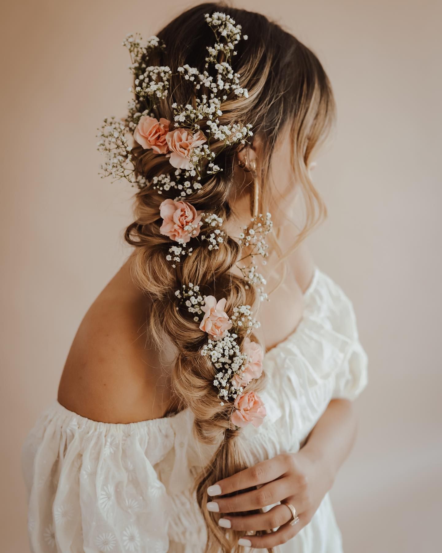 bridal braid hairstyle with flowers weaved throughout