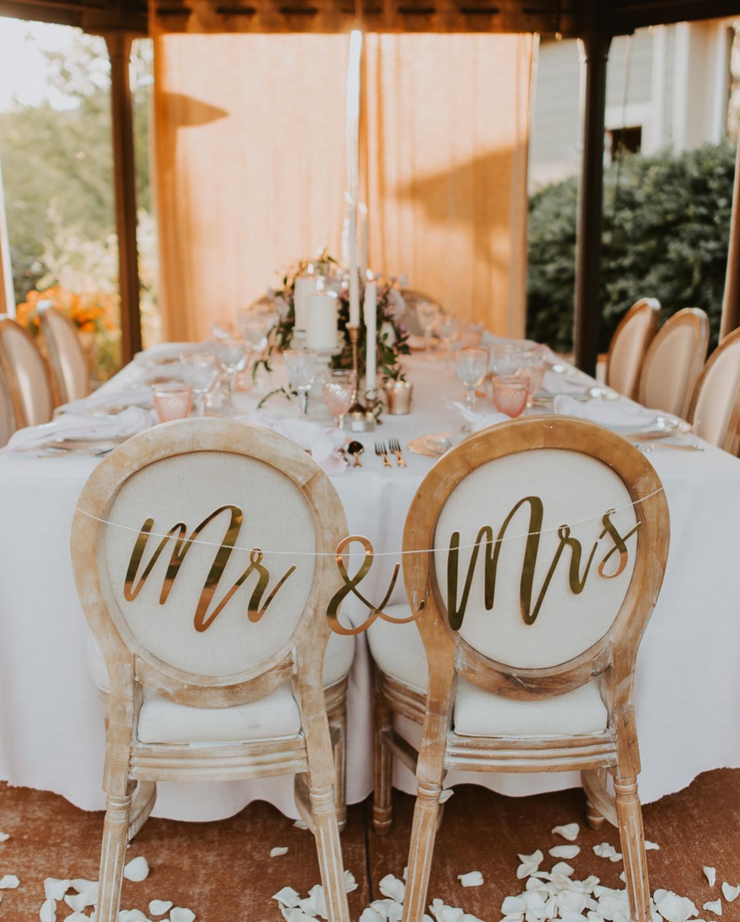 wedding reception table with mr and mrs signs hanging on chairs