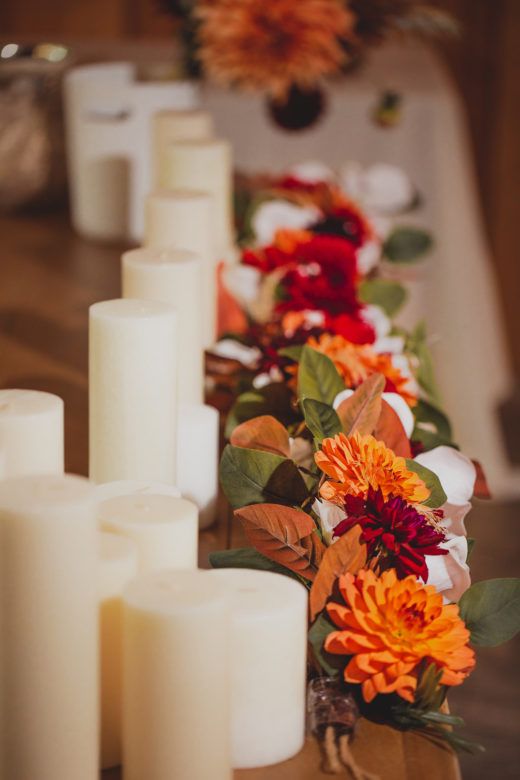 candle pillars and flowers on table