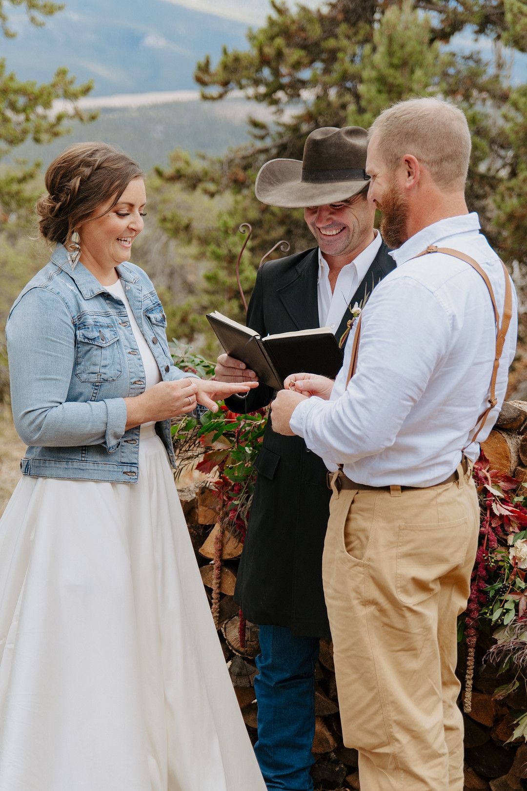 Bride and groom putting on rings at mountain elopement ceremony