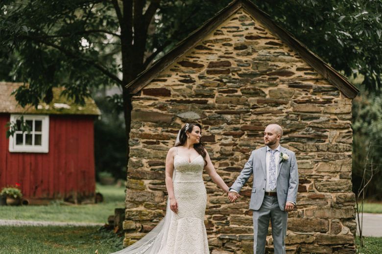 Bride and Groom holding hands in front of barn
