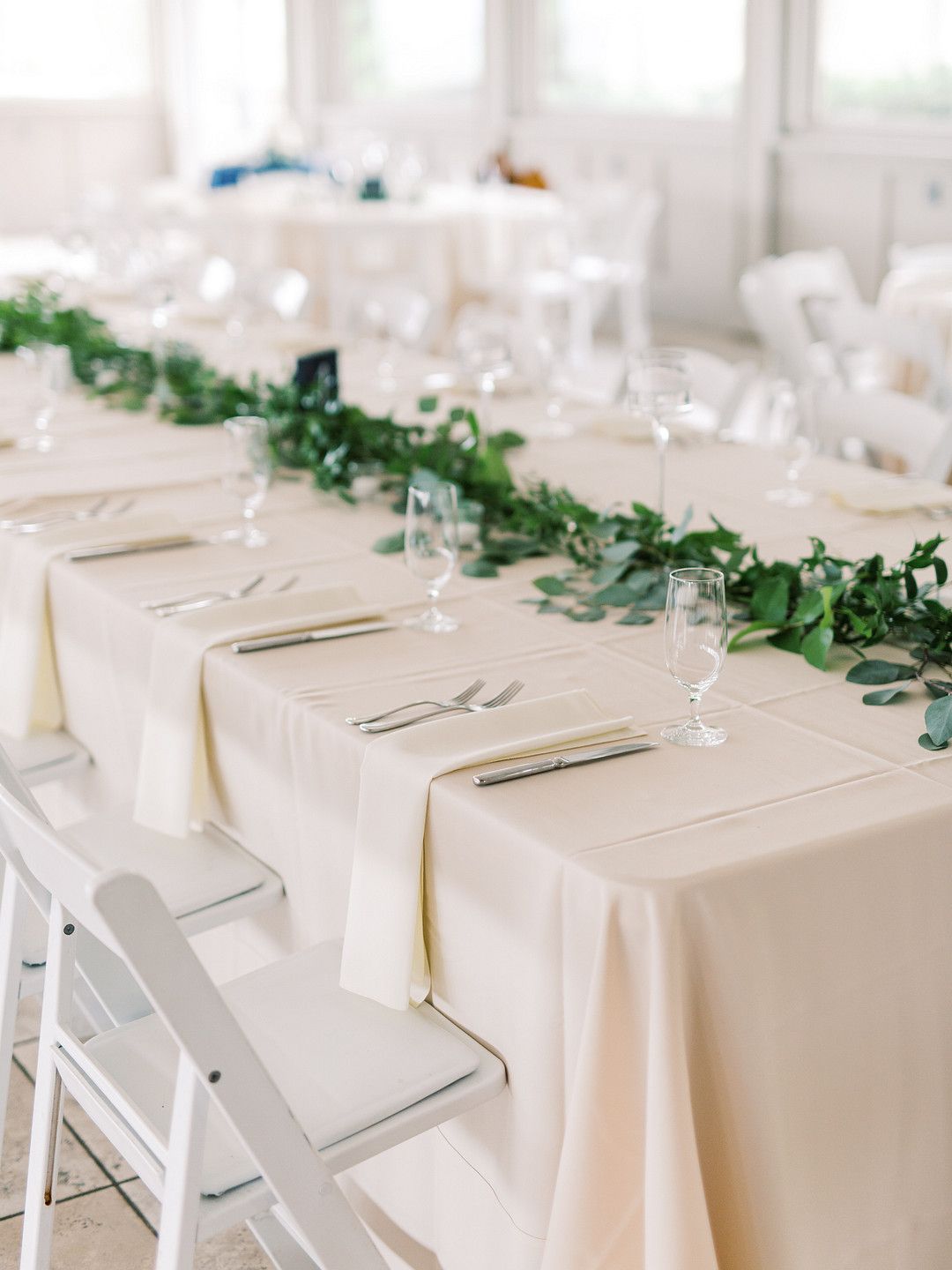 Wedding tablescape with white napkins and green florals
