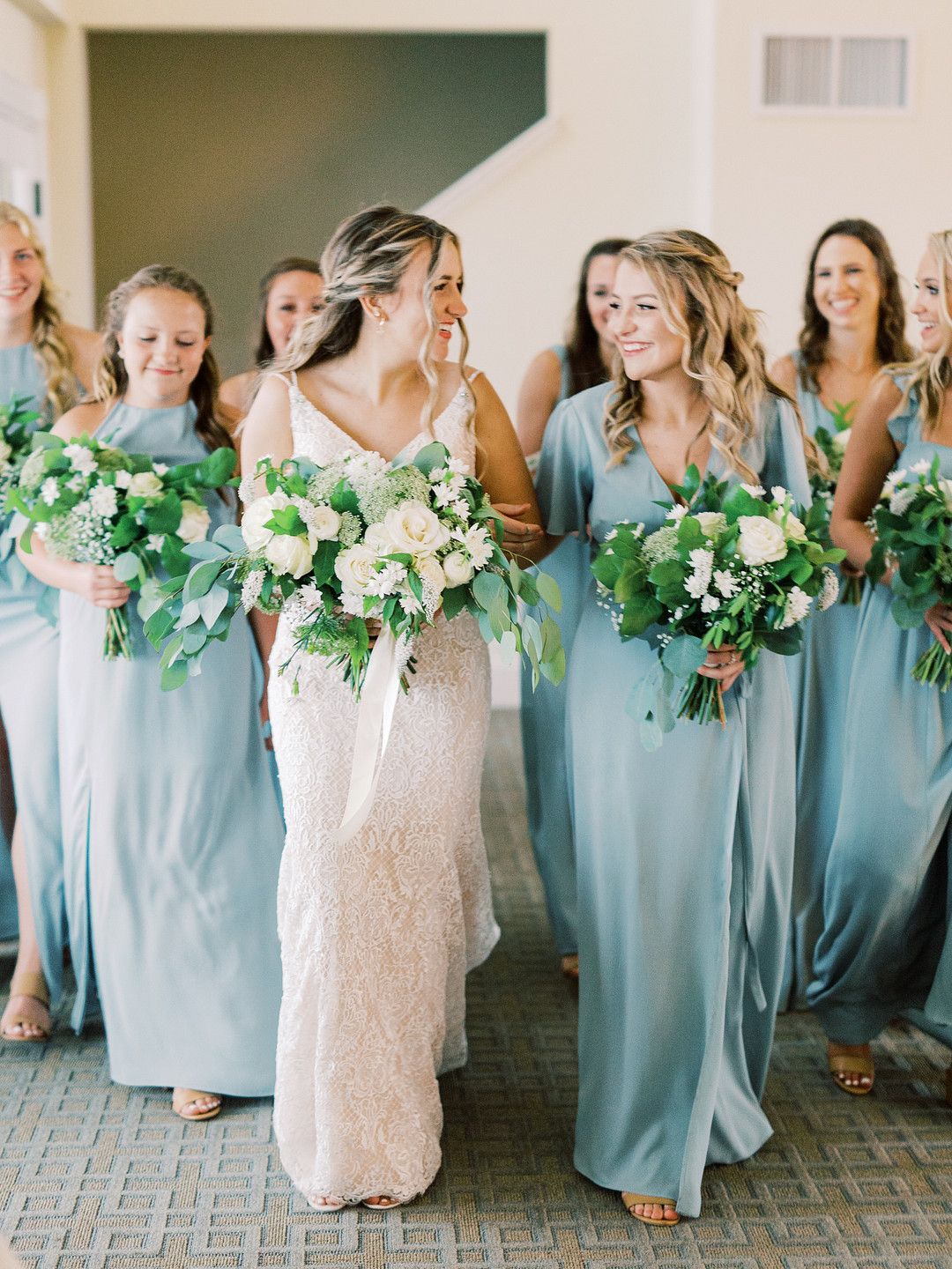 bride with her bridesmaids in dusty sage dresses