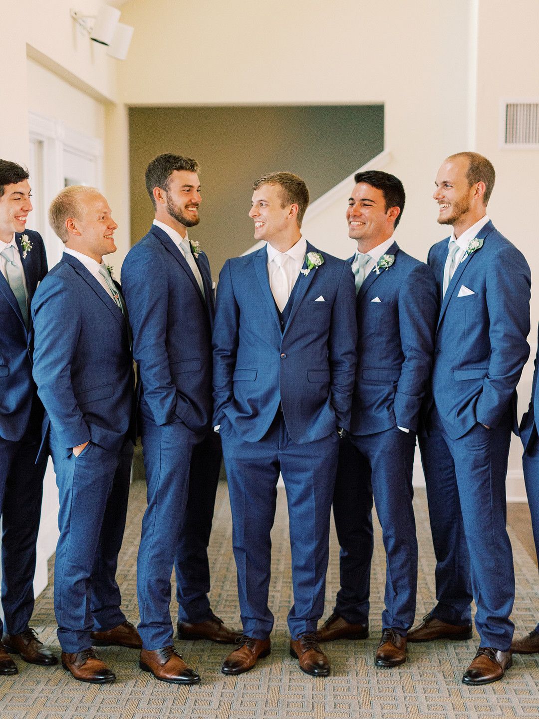 Groom and groomsmen standing together in navy suits