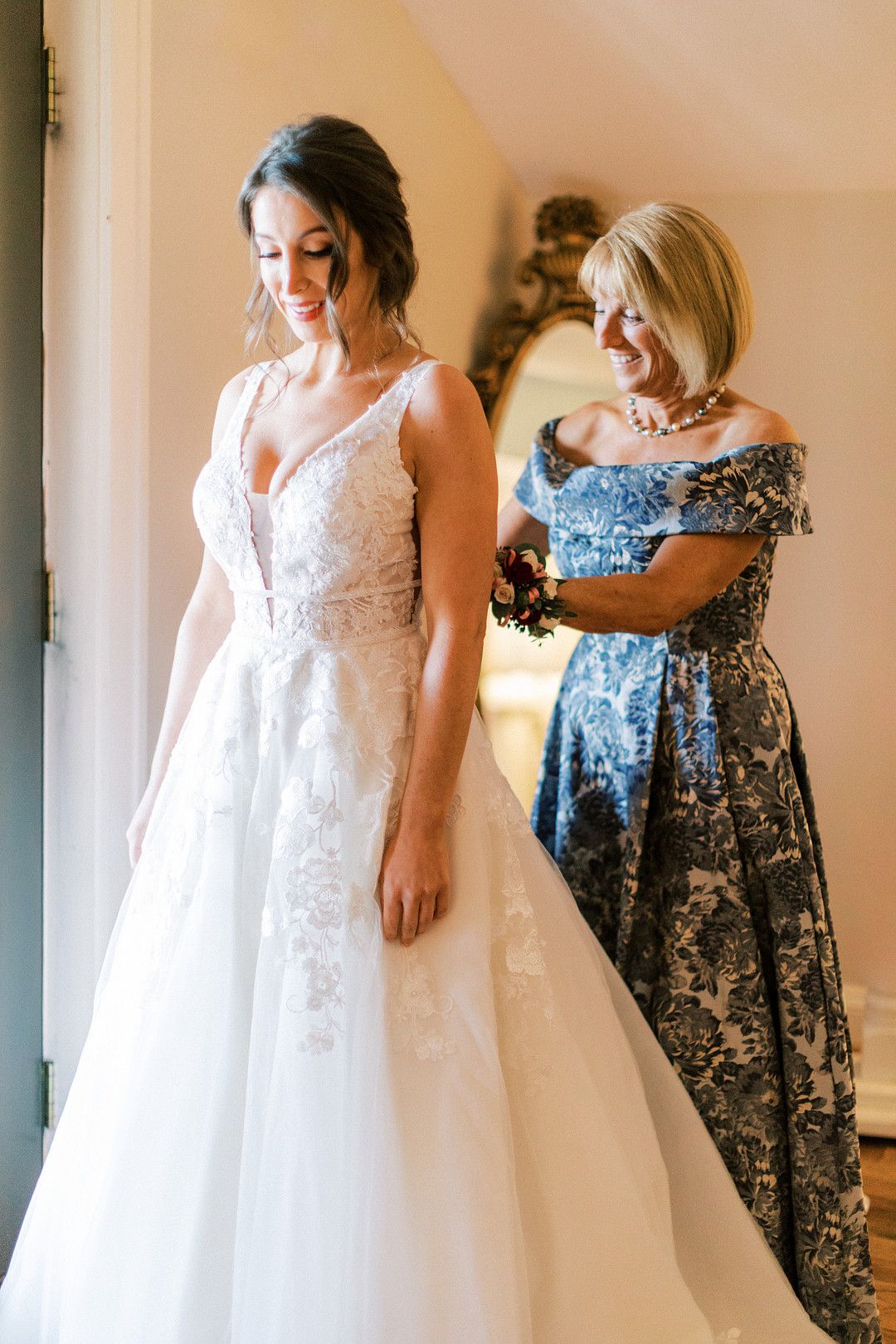 Mom helping bride with her dress