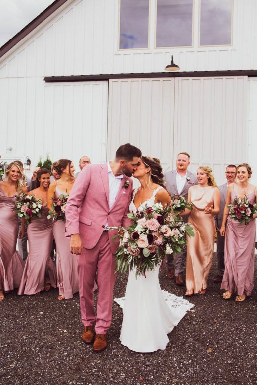 Bride and groom kissing in front of bridal party