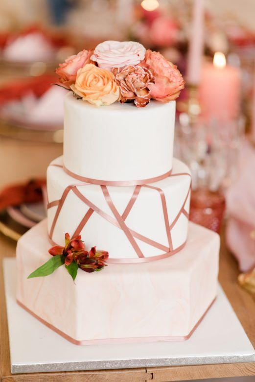 Wedding cake with pink geometric detail and real flowers