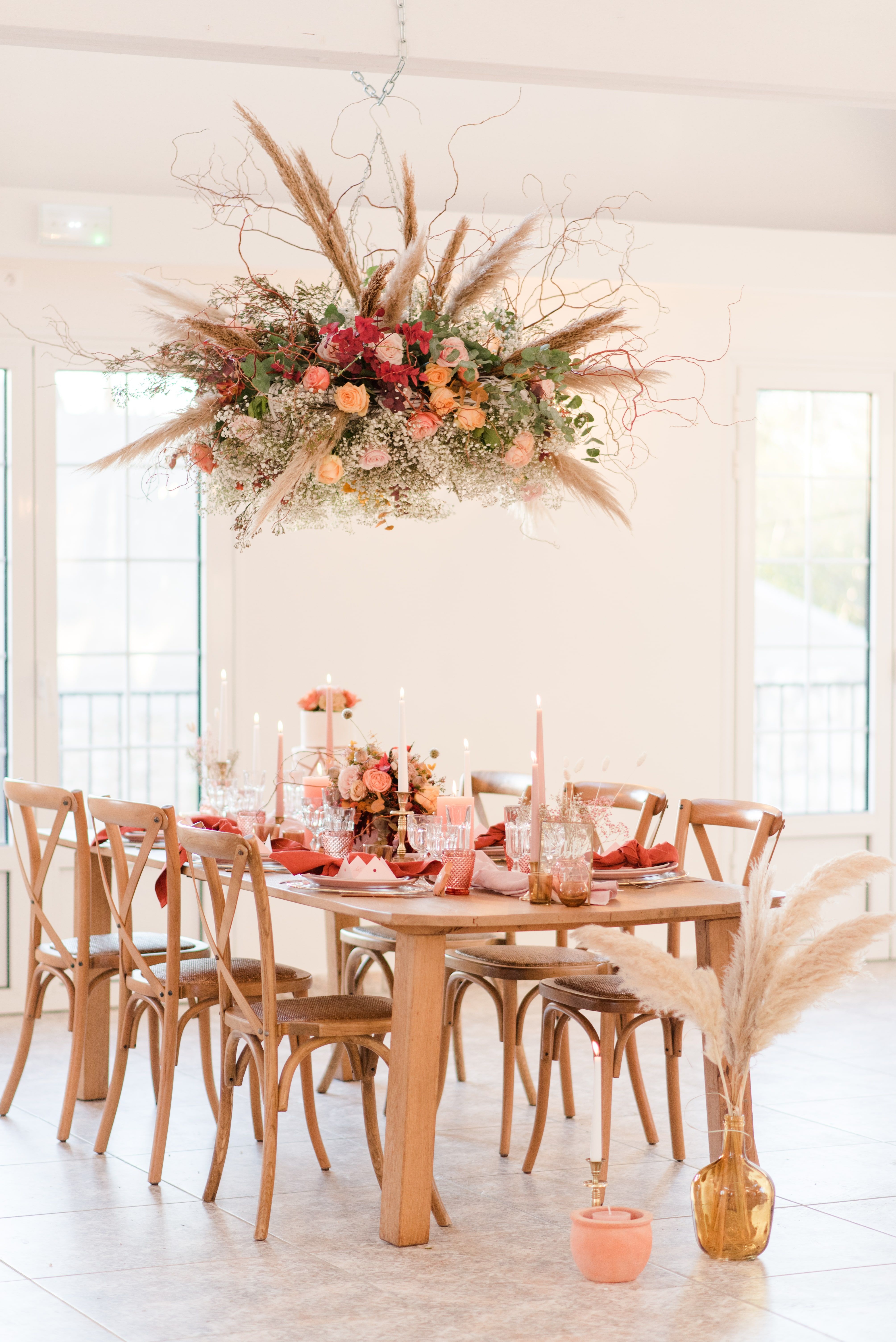 Ceiling wedding flower installation hanging above dinner table