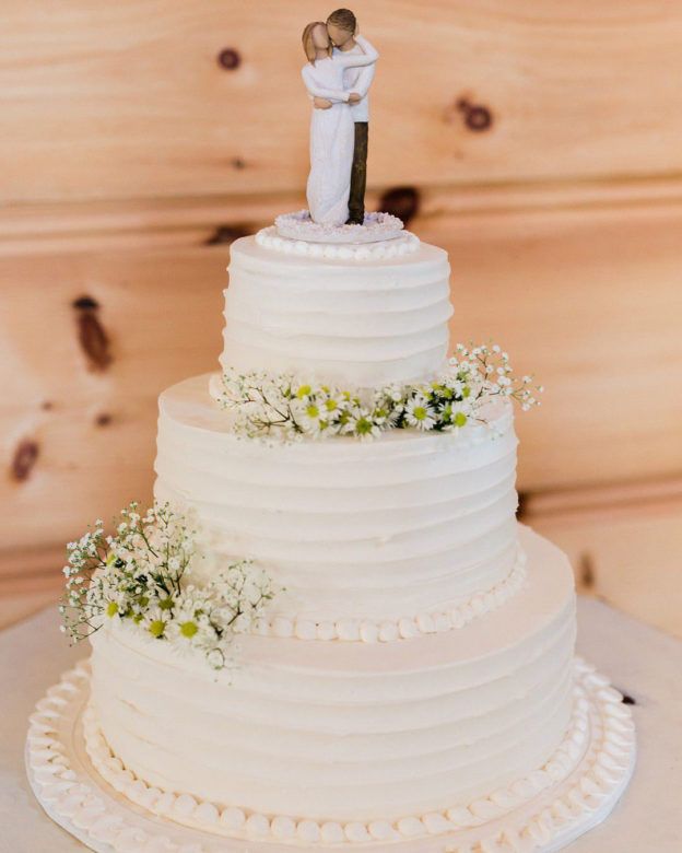 white wedding cake with bride and groom topper