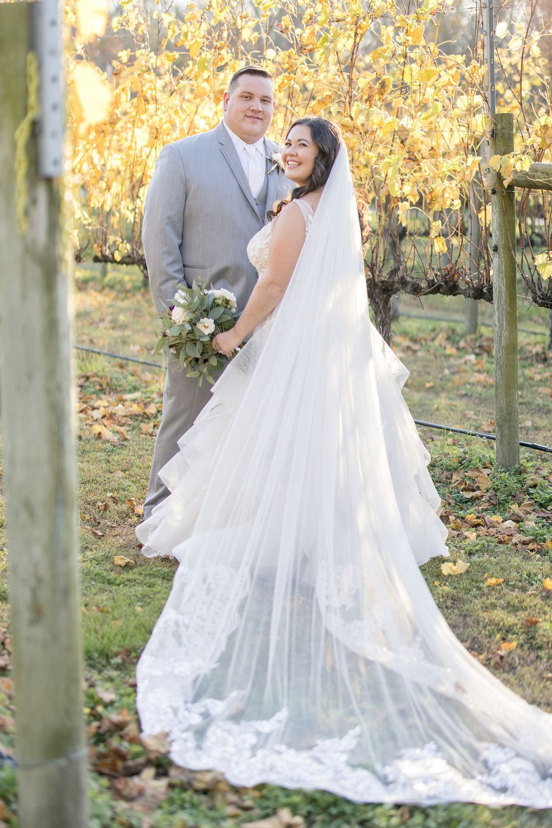 bride and groom standing together in vineyard