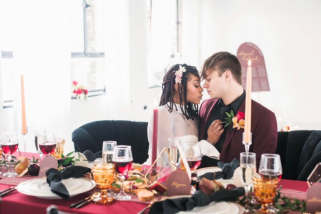 bride and groom sitting at bold and modern wedding table