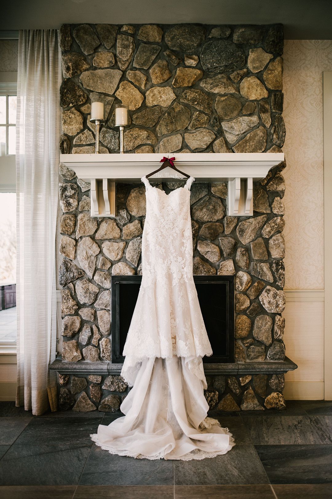 wedding dress hanging in front of fireplace