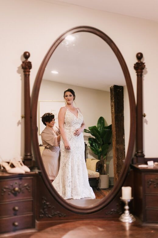 bride looking in mirror wearing wedding dress