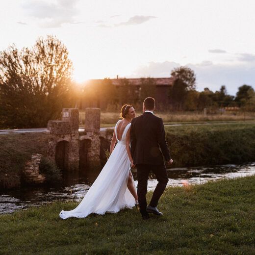 bride and groom walking into the sunset