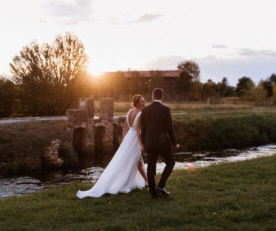 bride and groom walking into the sunset