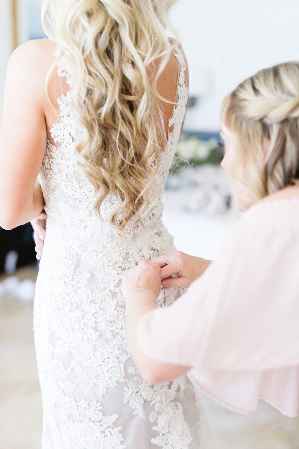 bridesmaid helping bride zip dress
