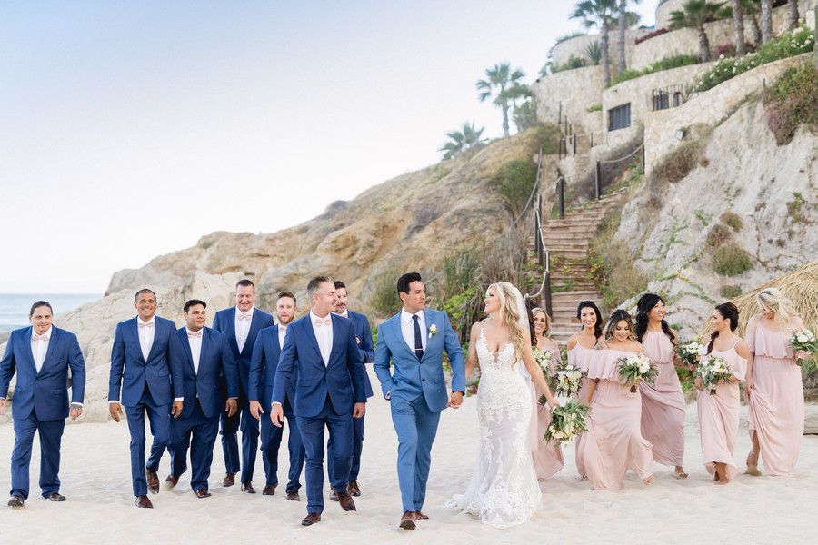 entire wedding party walking down the beach