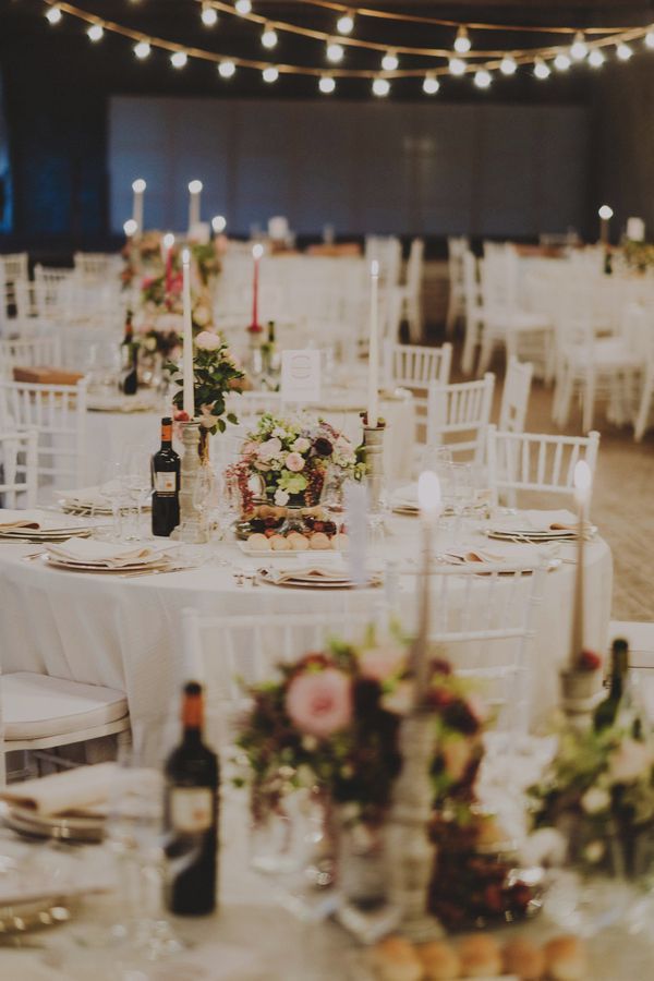 round wedding tables with floral centerpieces and romantic candles