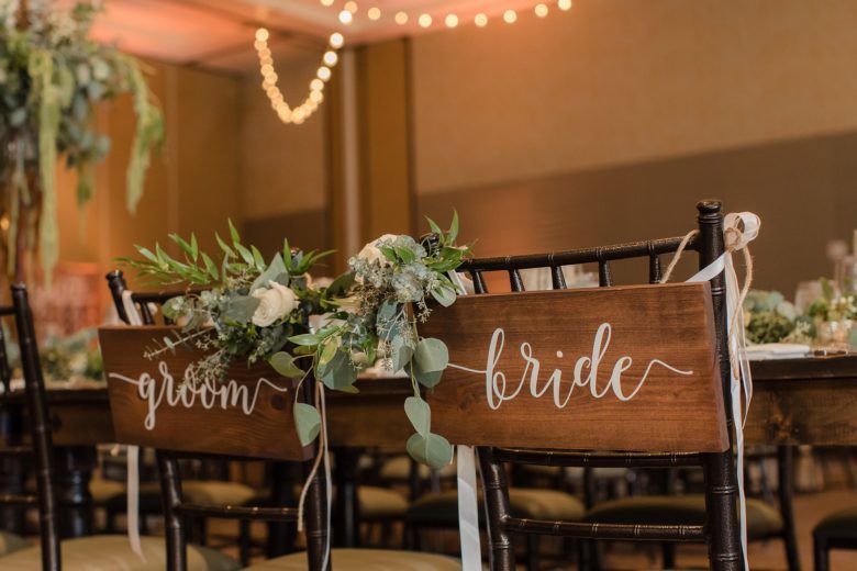 bride and groom signs on the back of chairs