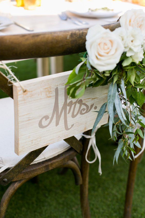 wooden mrs. sign hanging on the back of chair
