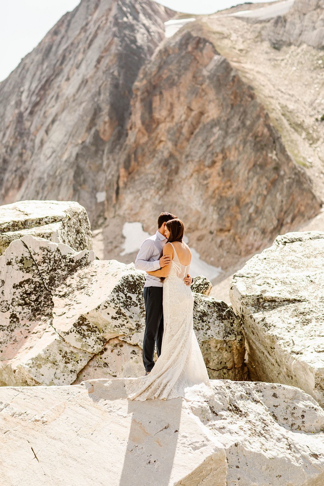 bride and groom embracing in front of mountain tops