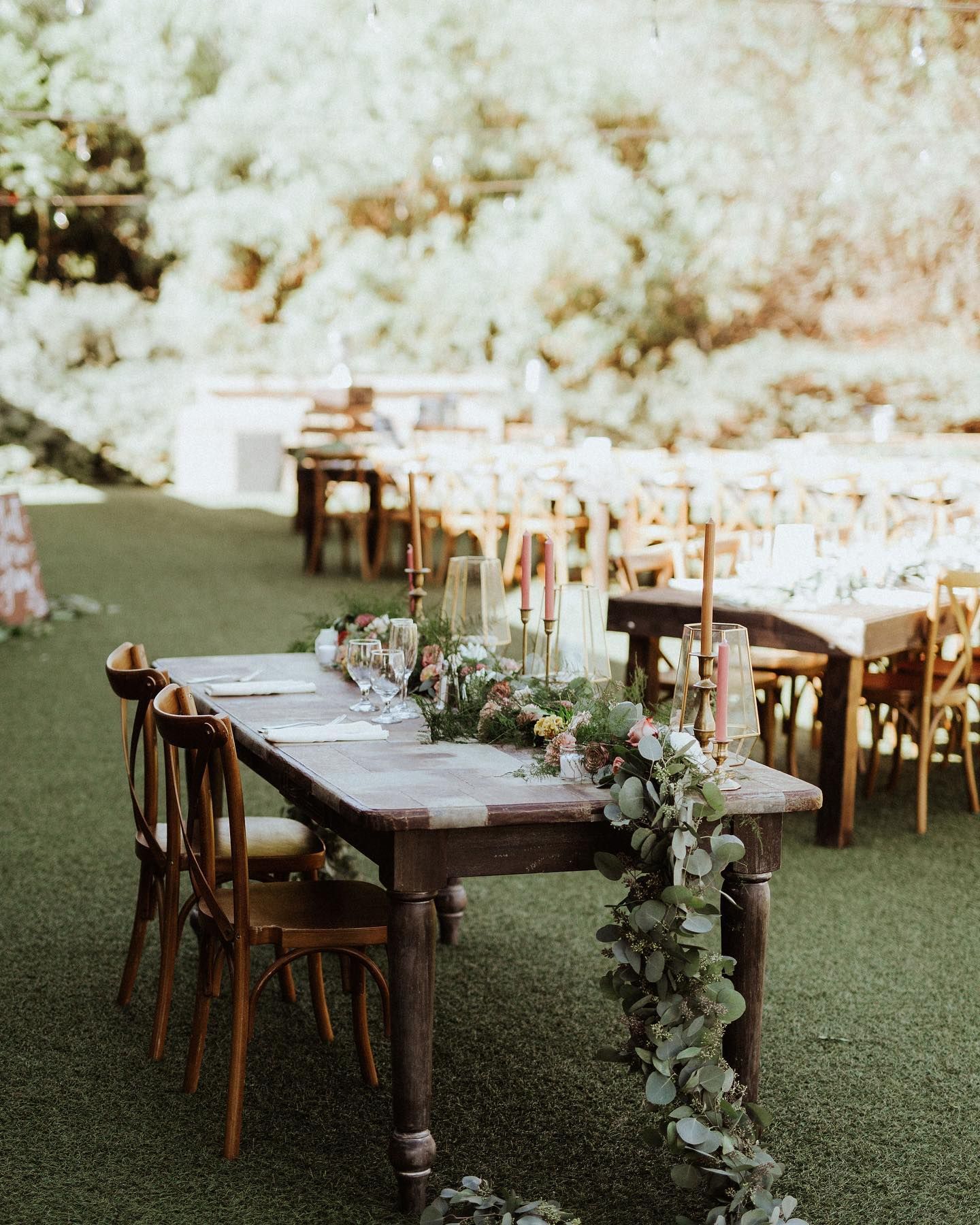 dark wood table with long floral garland as the centerpiece