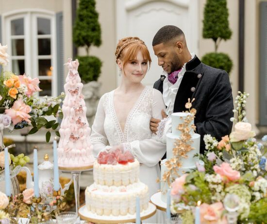 bride and groom smiling in front of table weith desserts from bridgerton netflix styled wedding shoot