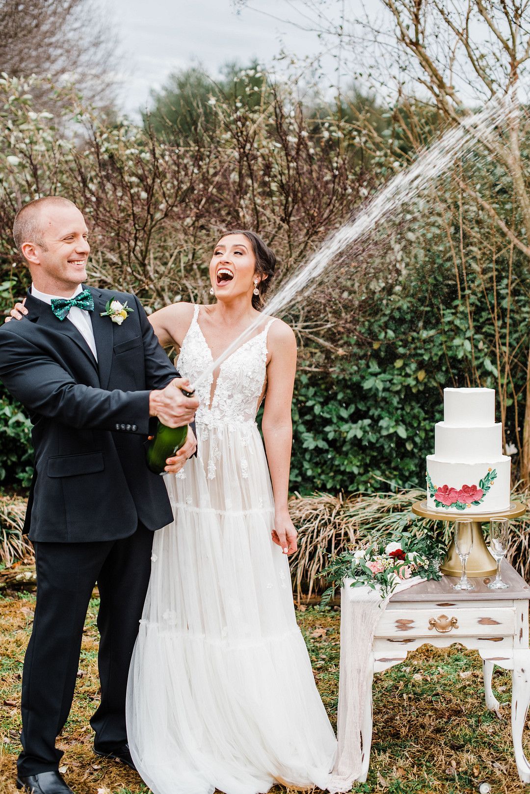 bride and groom popping champagne at colorful petal themed wedding styled shoot