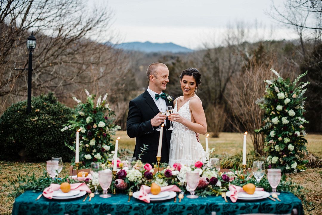 bride and groom at colorful petal themed wedding tablescape