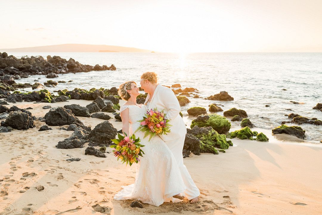 two brides kissing on the beach