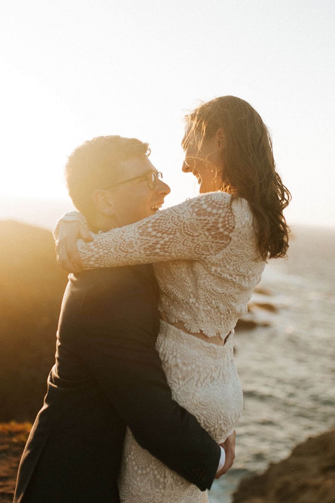 bride and groom embracing at sunset in big sur