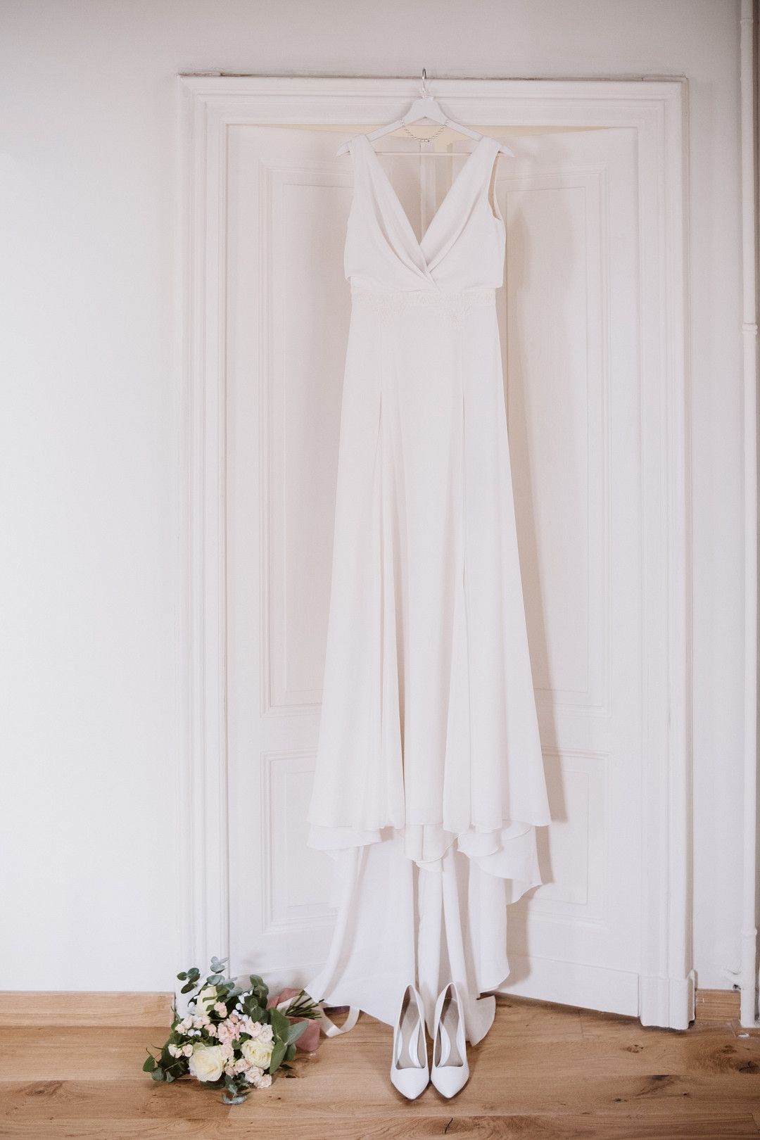 wedding dress hanging in from of bedroom door