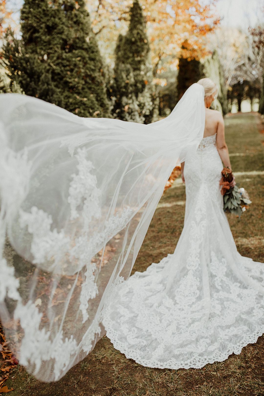 bride wearing lace wedding gown with veil