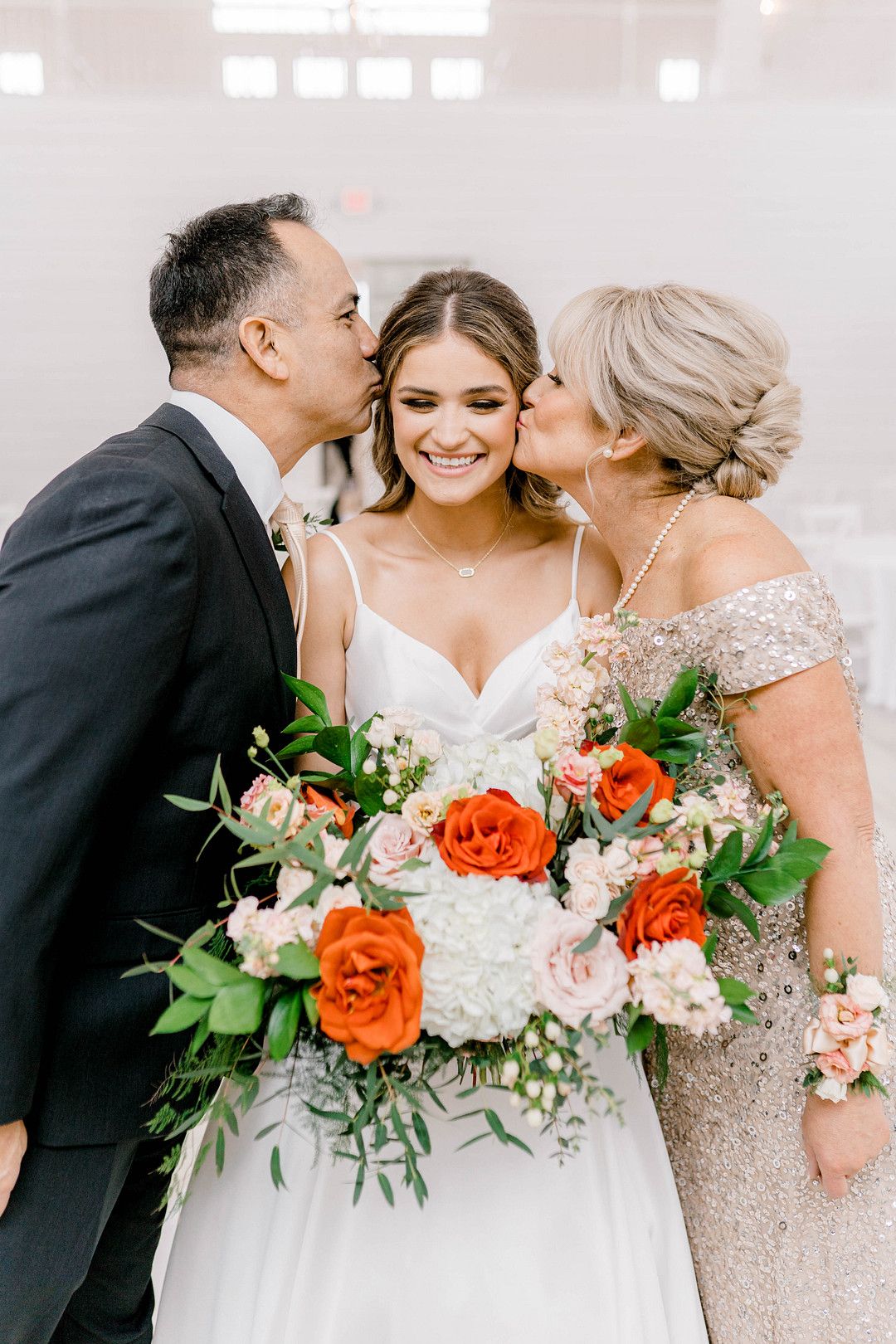 photo of bride with her parents on her wedding day