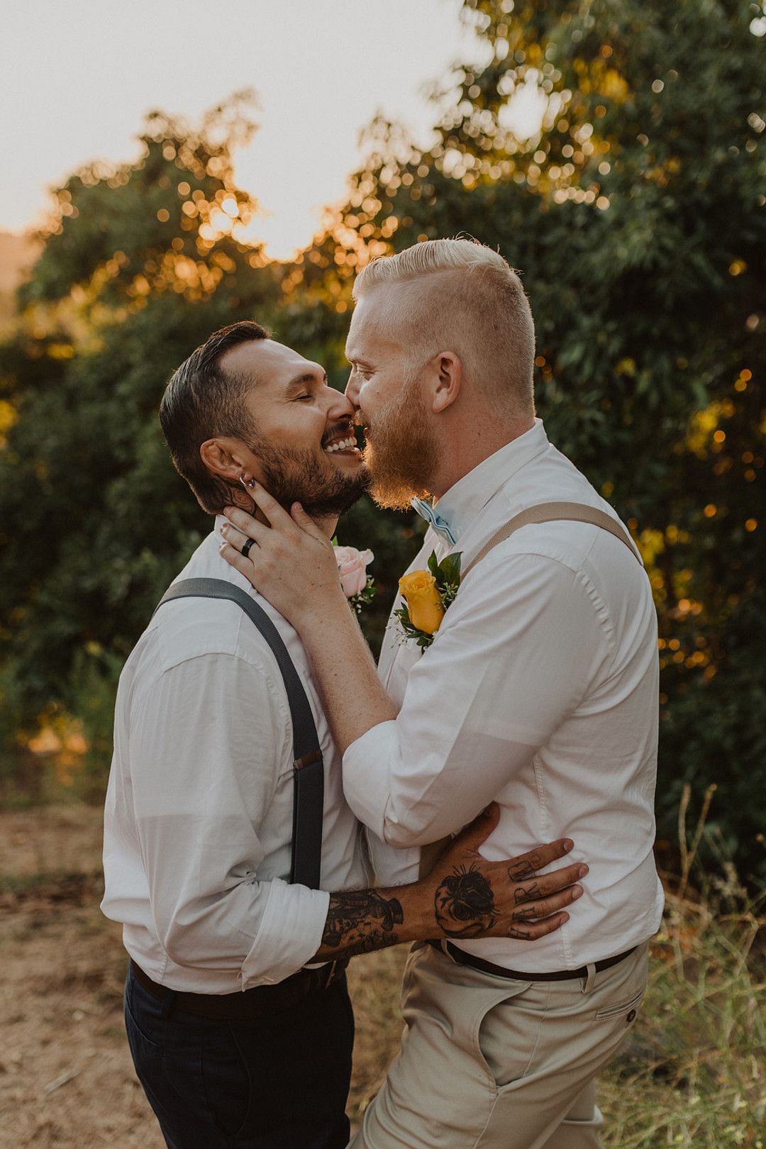 grooms kissing one another at their rustic intimate farm wedding