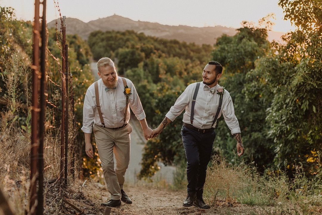 grooms walking hand in hand at their intimate rustic farm wedding