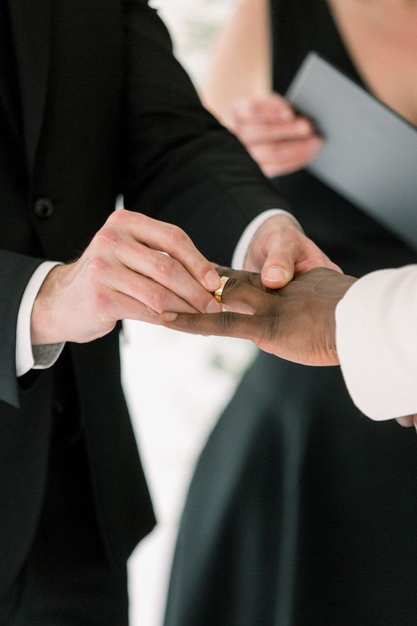 groom placing ring on partners finger