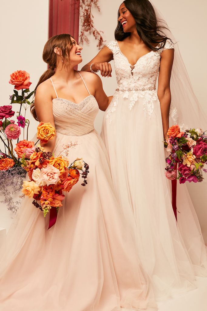 two brides wearing blush colored wedding dresses