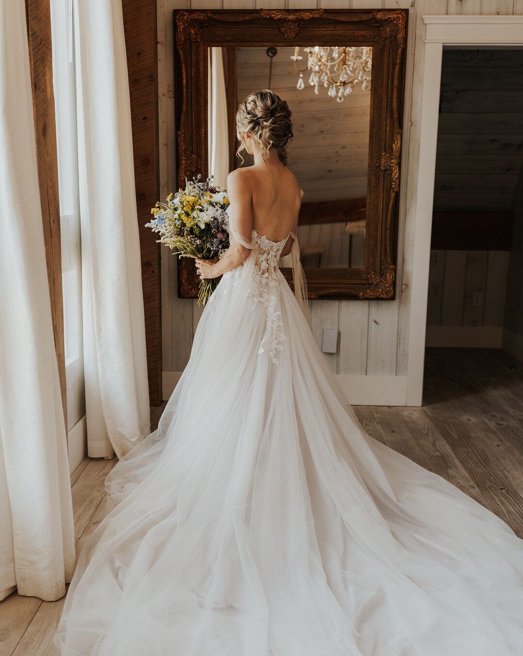 bride standing in a beautiful long gown for the romantic wildflower inspiration shoot