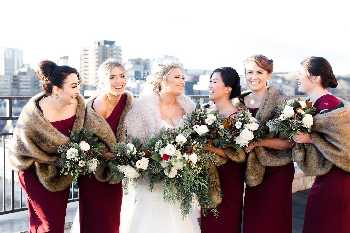 winter bridal party with bridesmaids wearing faux fur bridesmaid wraps