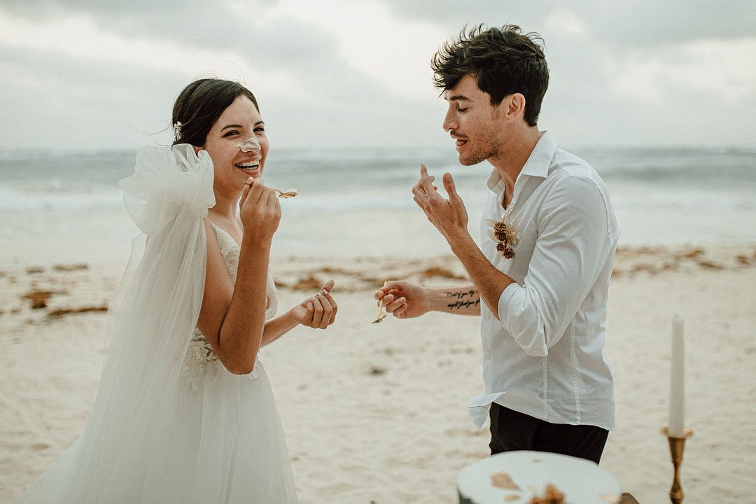 bride and groom smashing cake in each other's faces