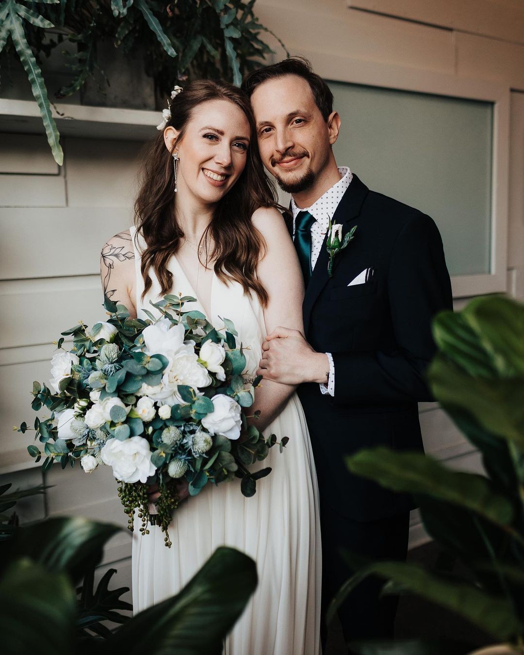 A couple with a silk floral wedding bouquet 
